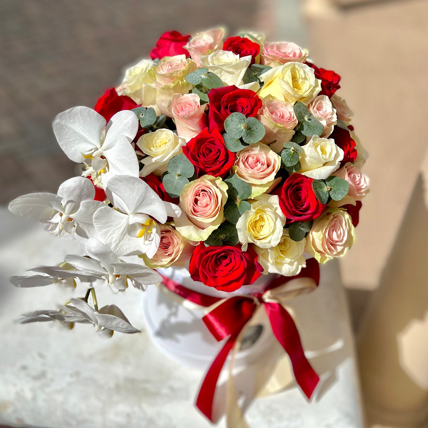 Red, Yellow roses on concrete bench with red ribbon