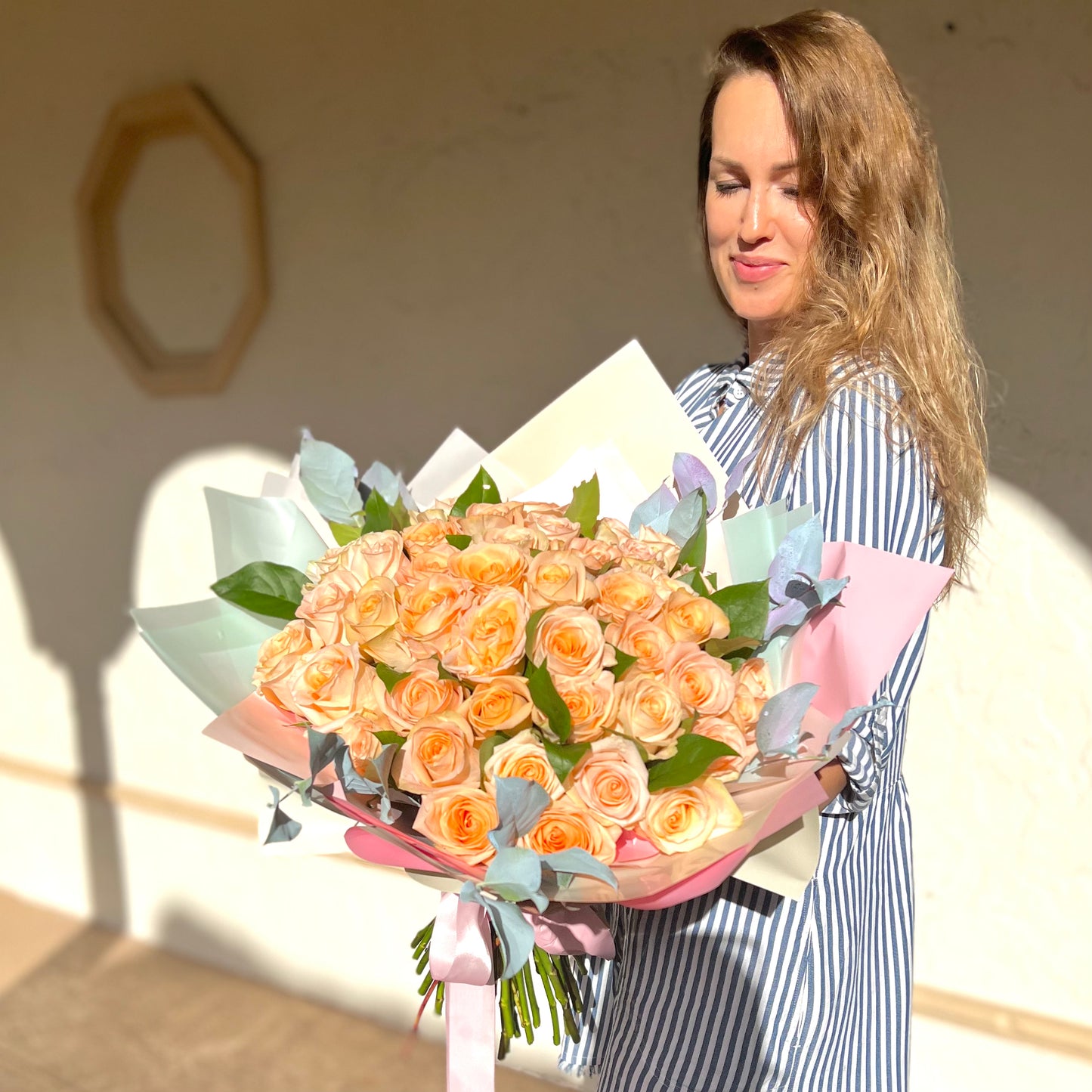 women in pin stripped dress holding flowers
