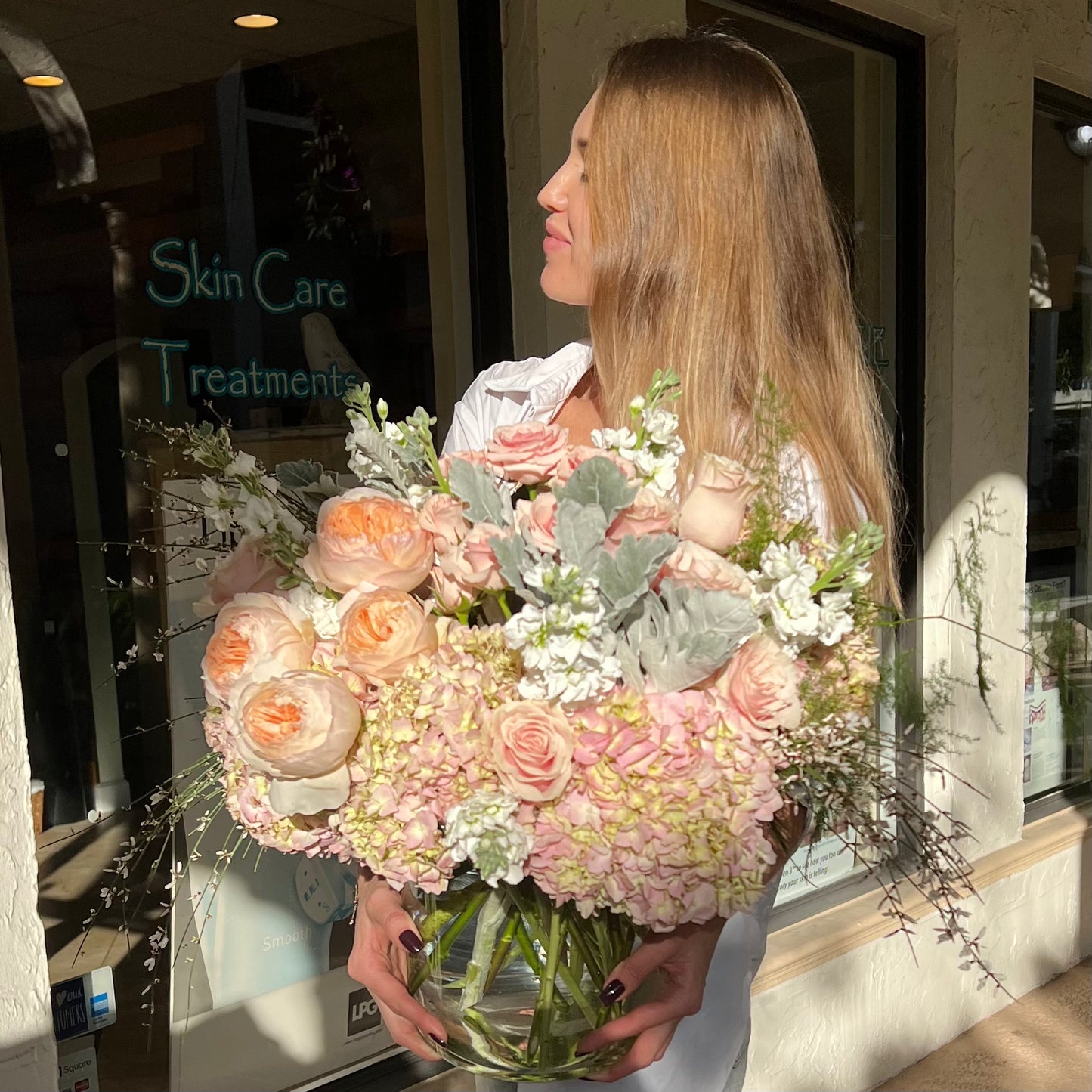 A woman carrying large circle vase of flowers
