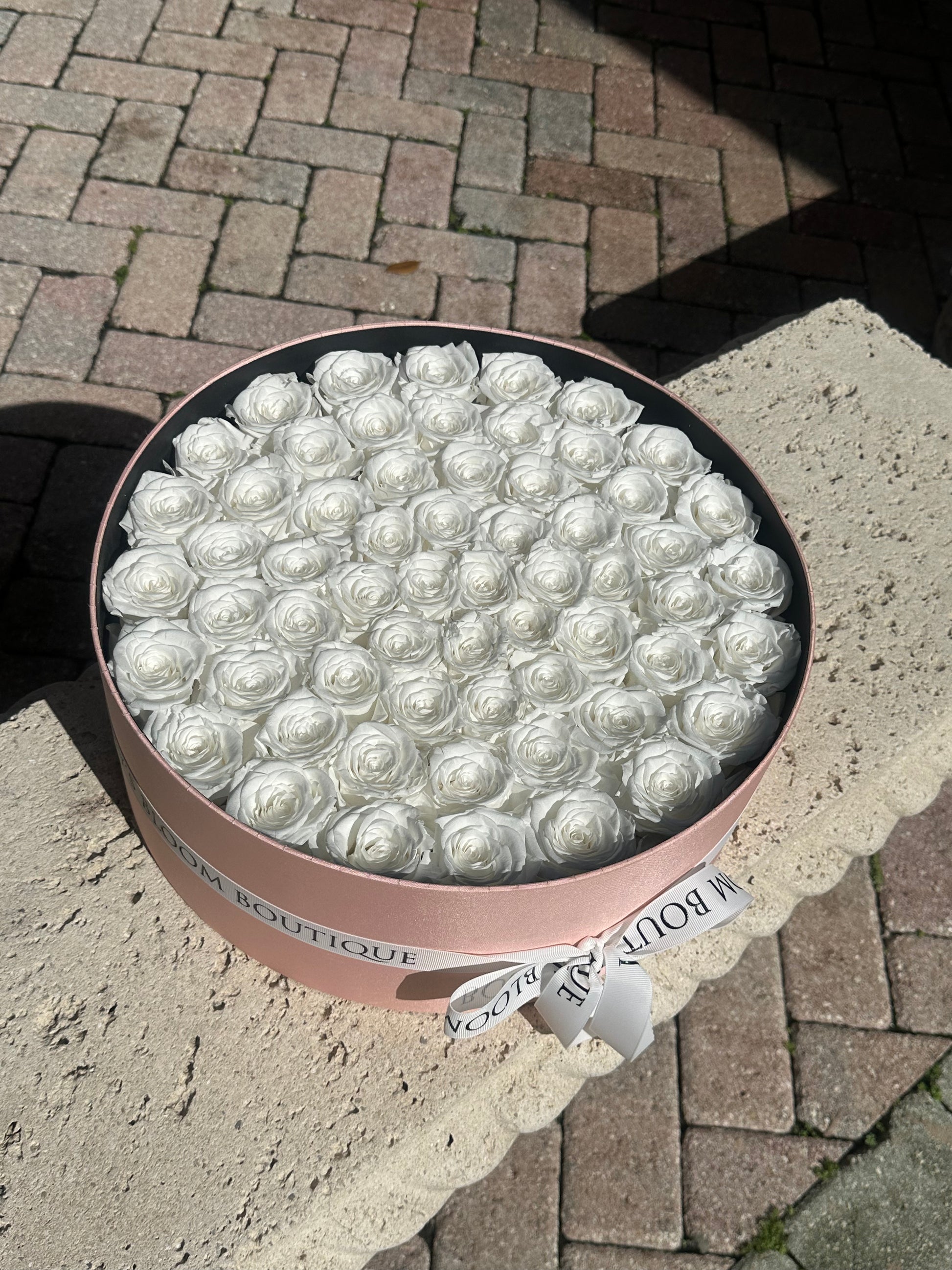 preserved white roses in a round box
