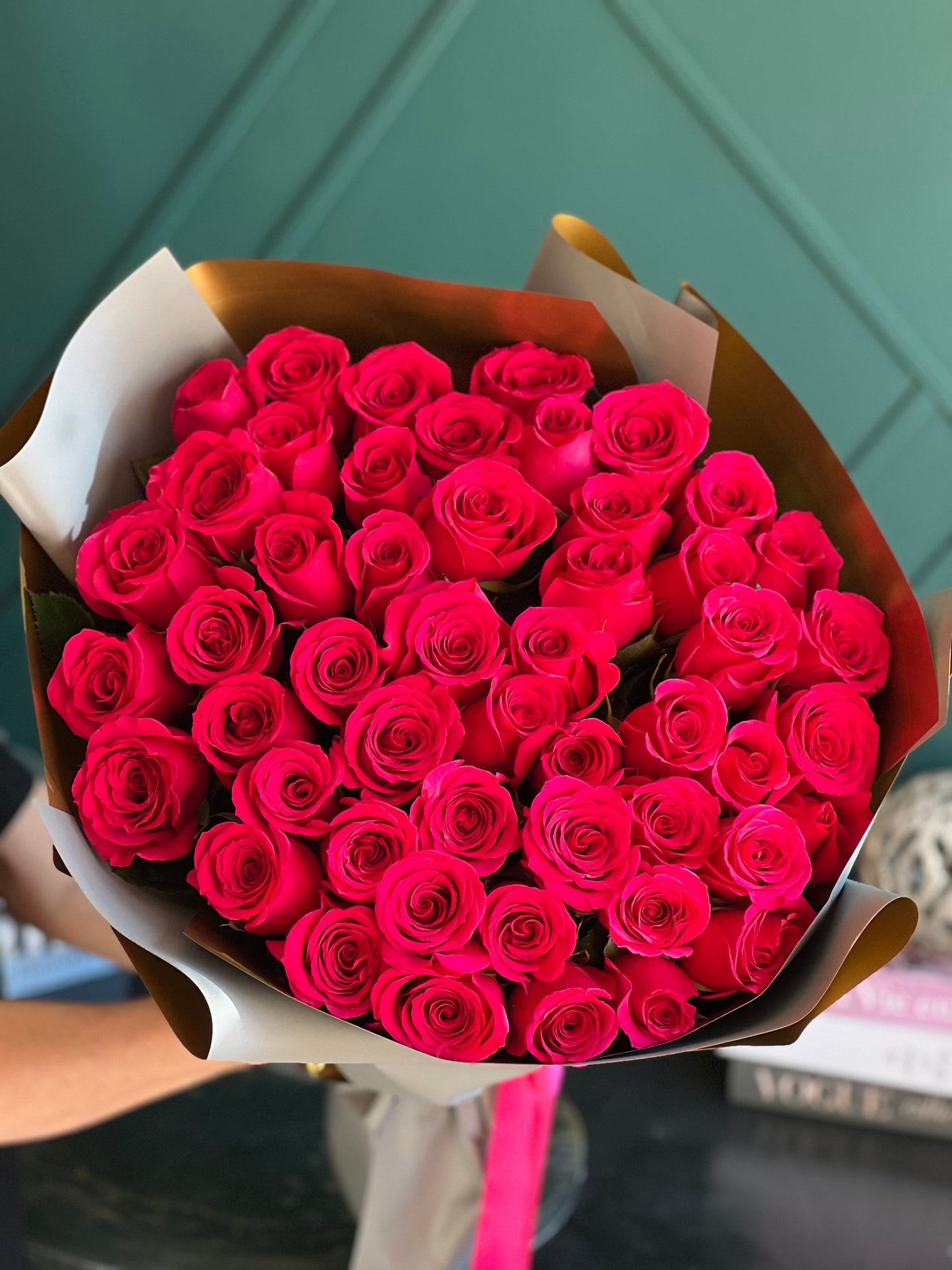 a bouquet of hot pink roses in paper wrap