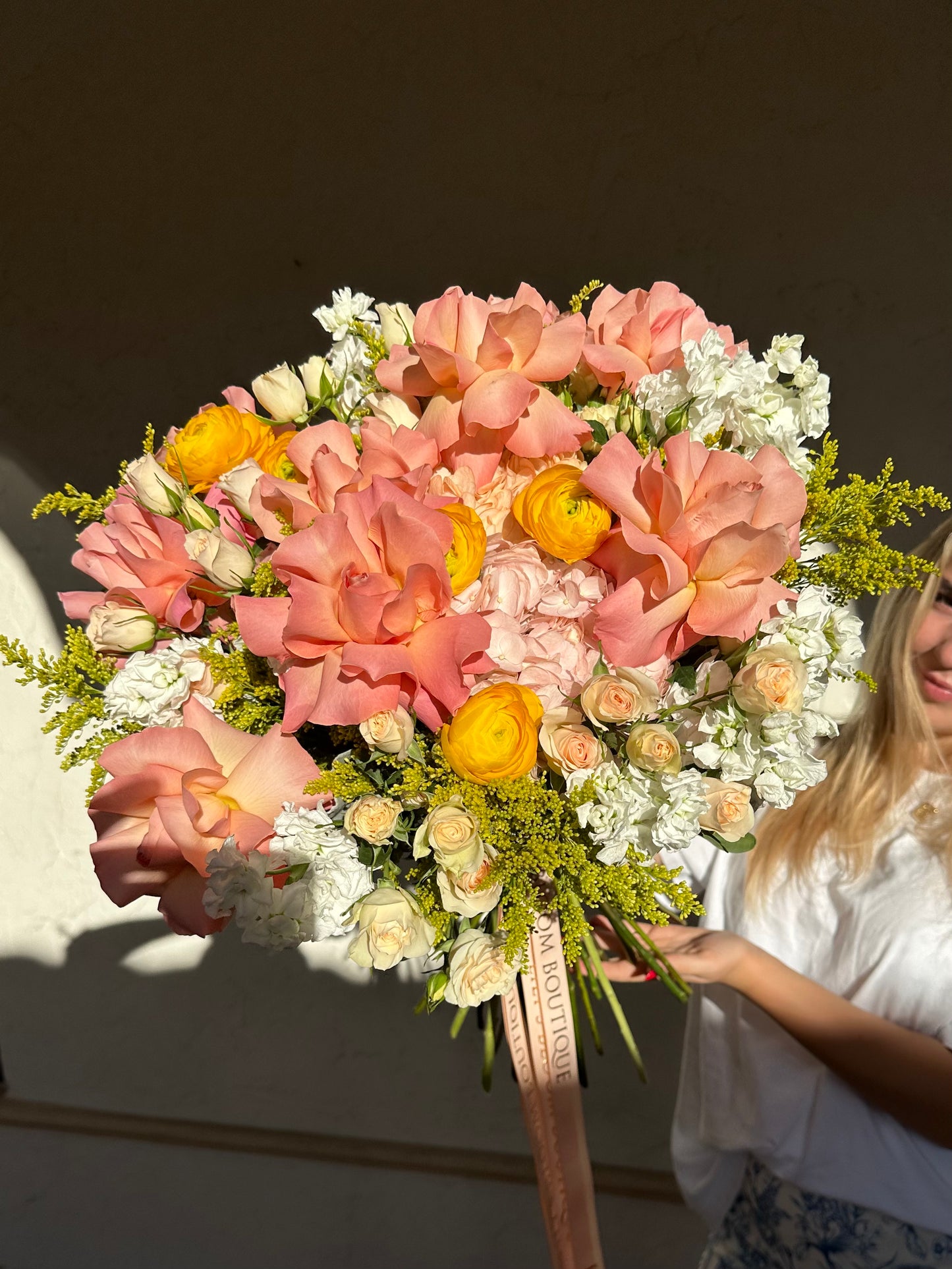 a pretty girl holding peach and white flowers