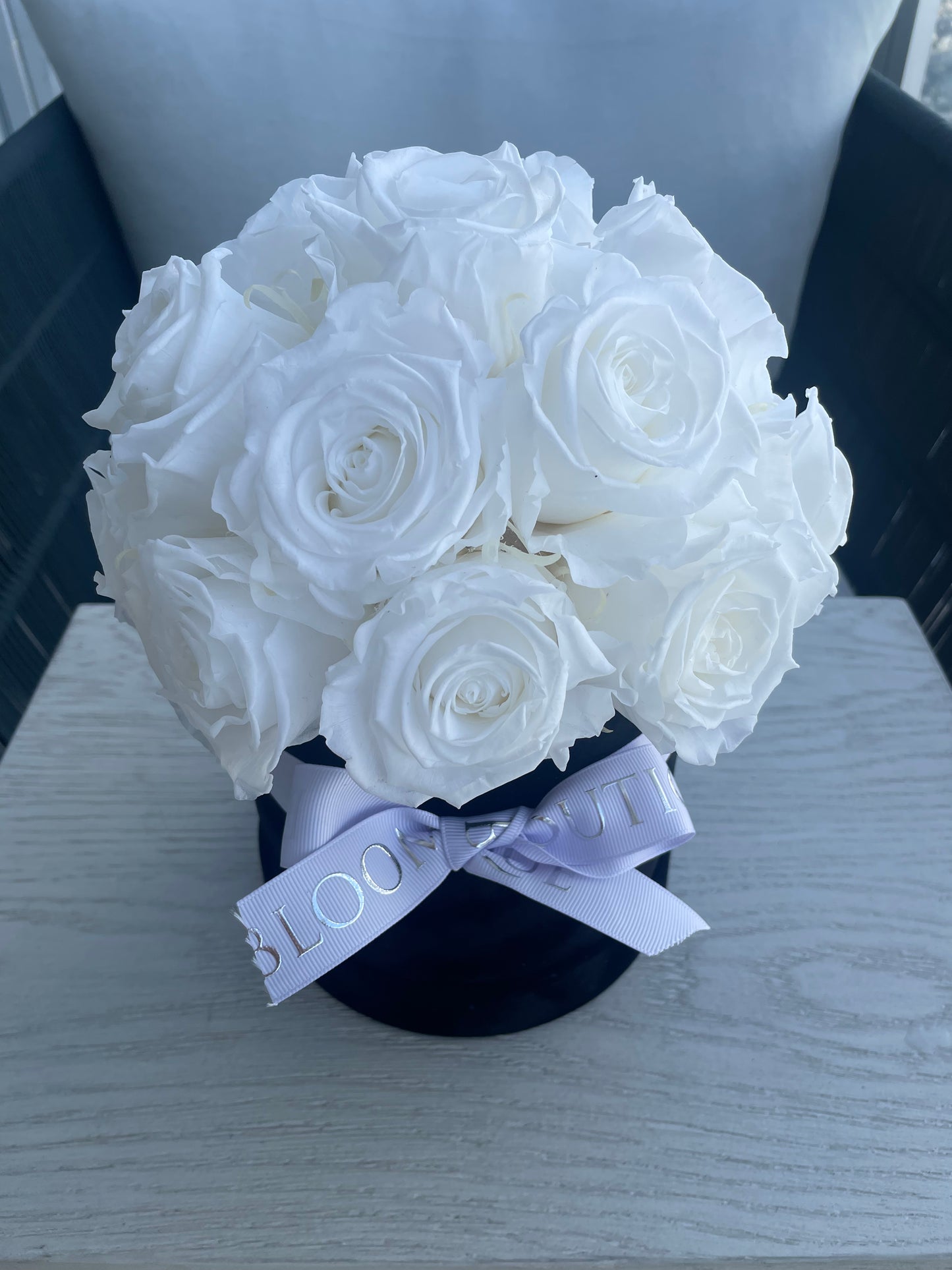 White preserved roses in black box