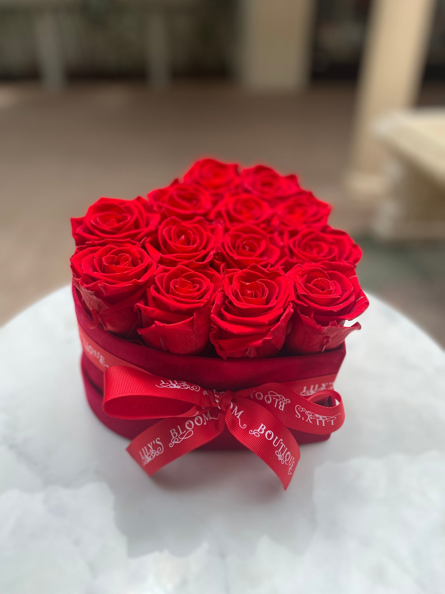 Red Roses with box with red Ribbon on a table