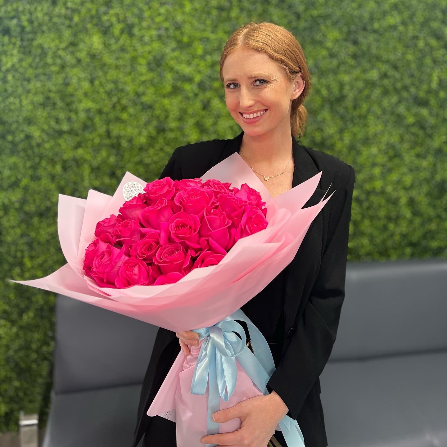 Women with red hair holding beautiful red roses outside 