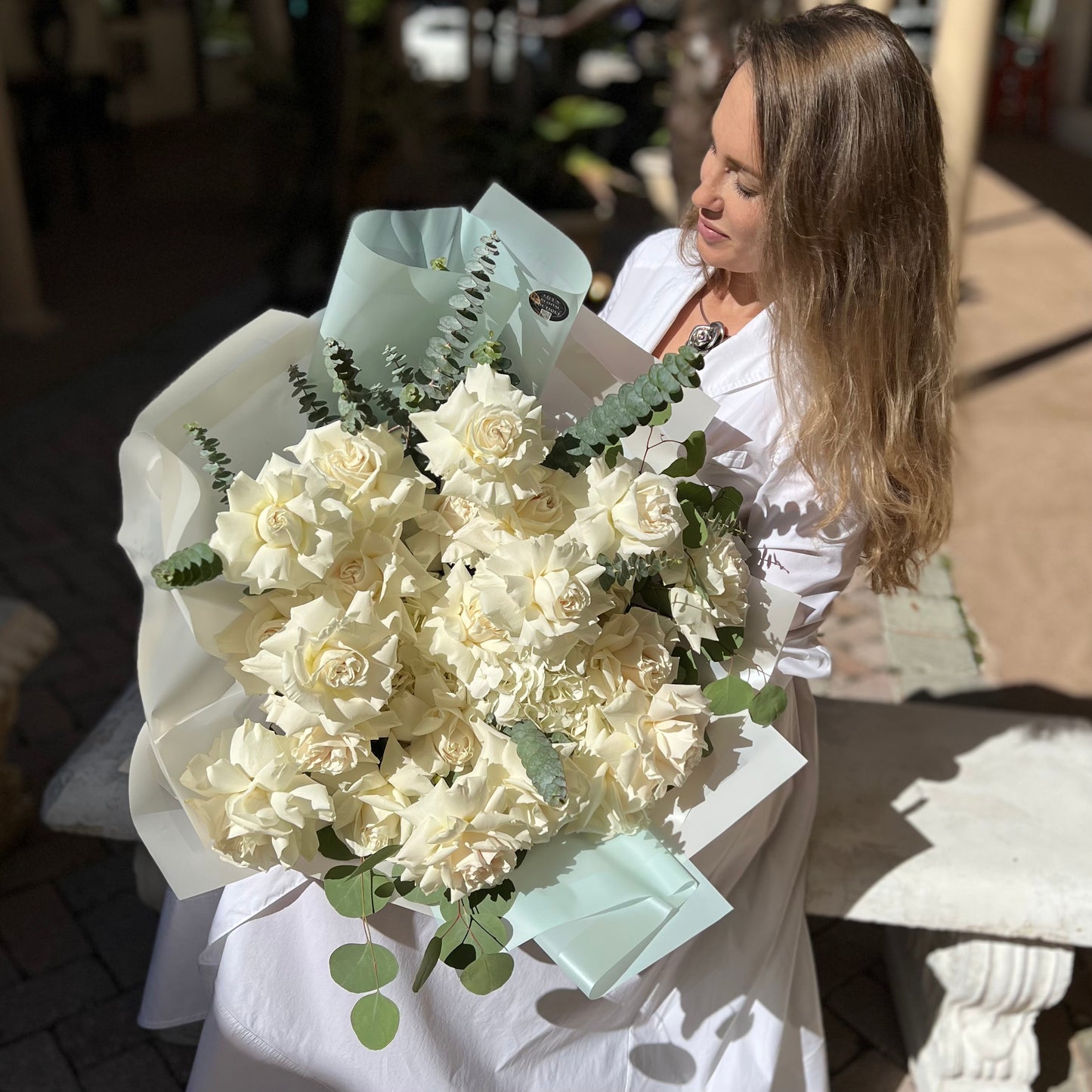 A beautiful woman with a gorgeous bouquet of white flowers