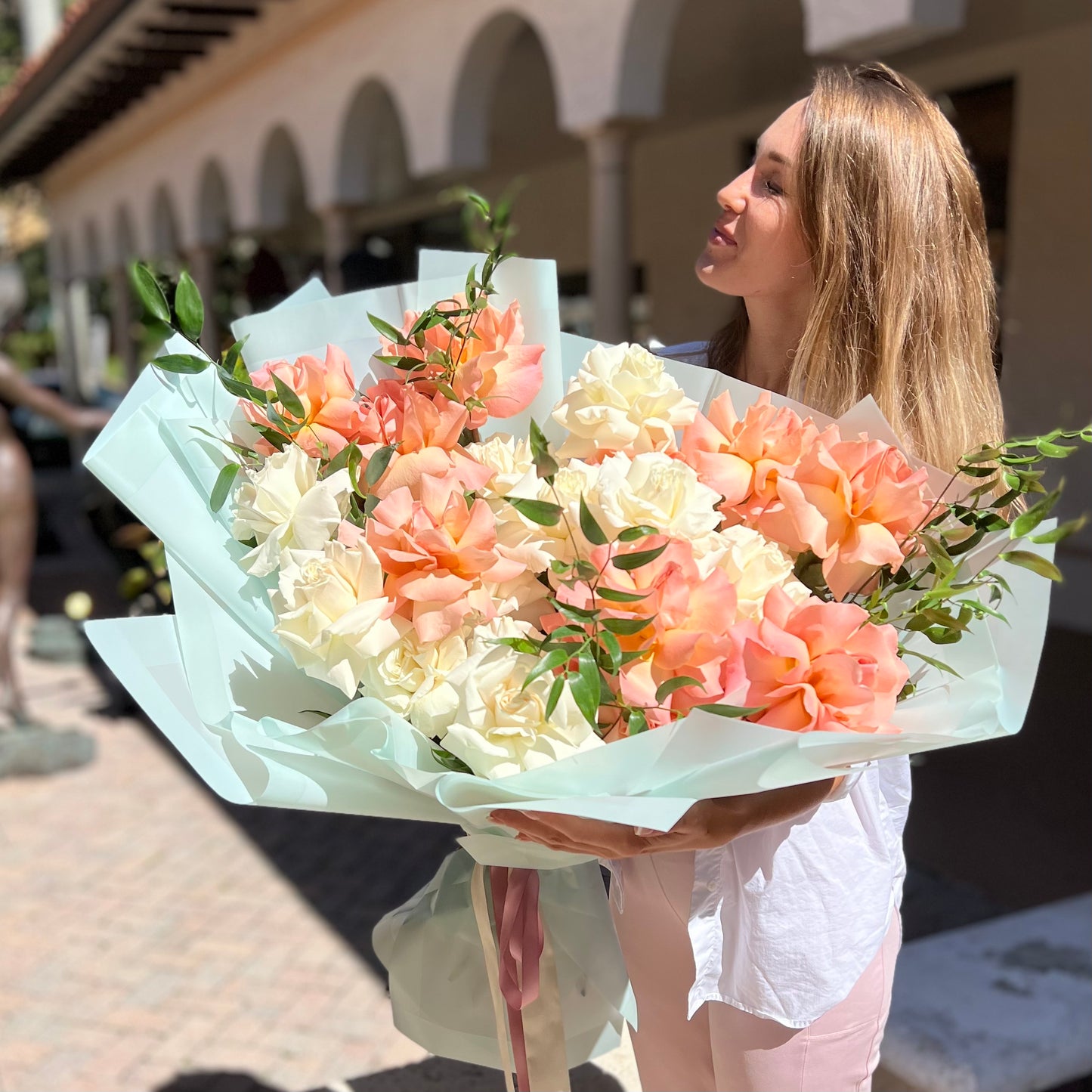 A woman holding large bouquet of flowers 
