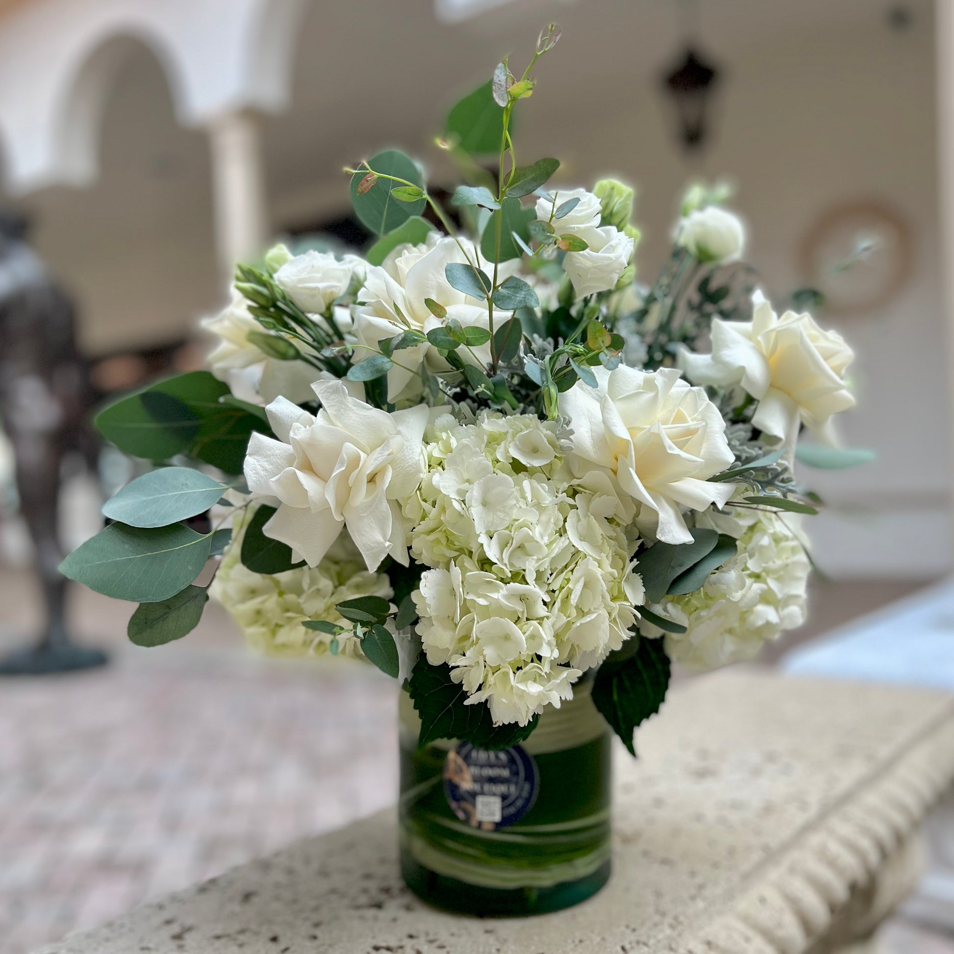 White roses, hydrangeas, lisianthus, Dusty Miller in a vase