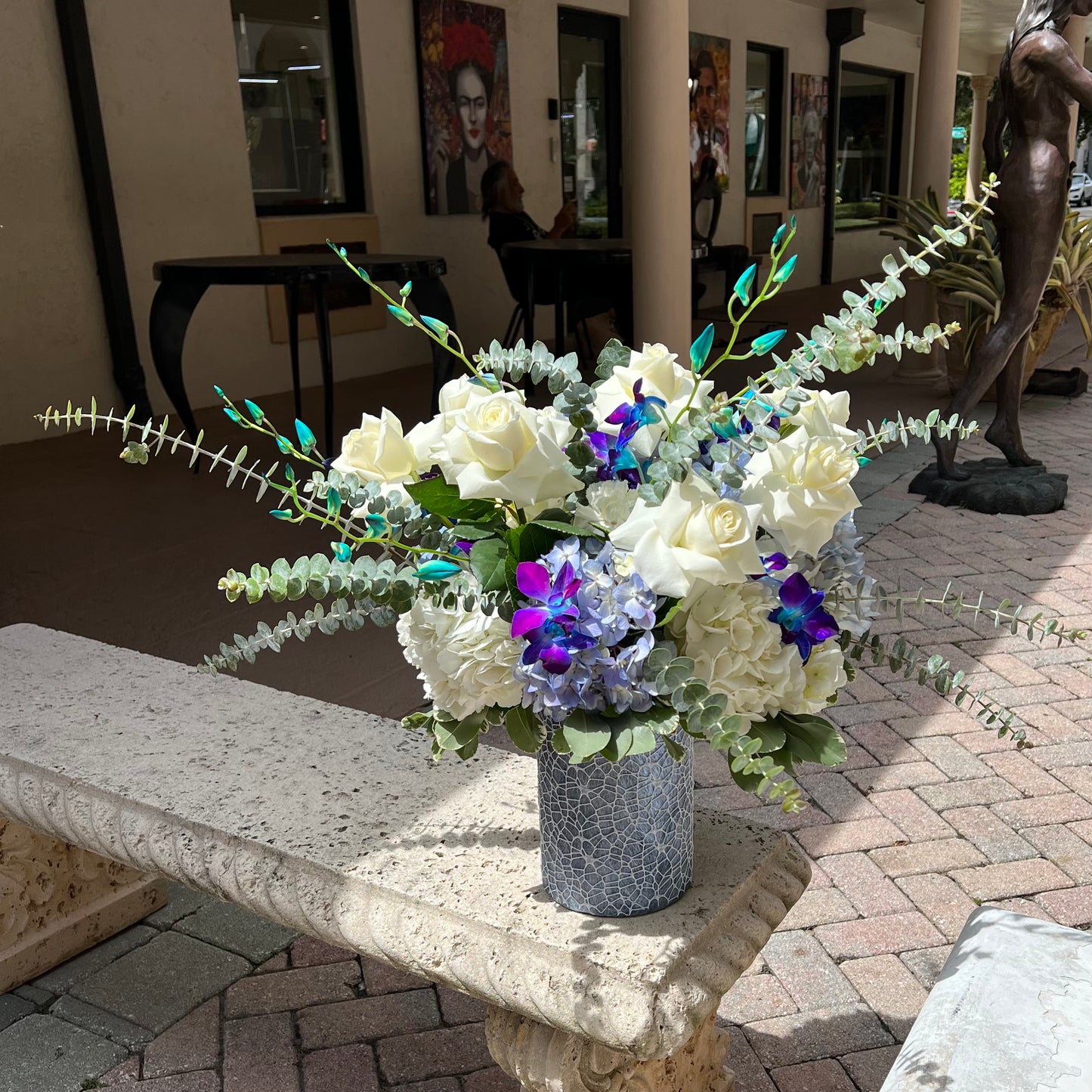 Beautiful full flower bouquet on concrete bench with blue and white flowers 