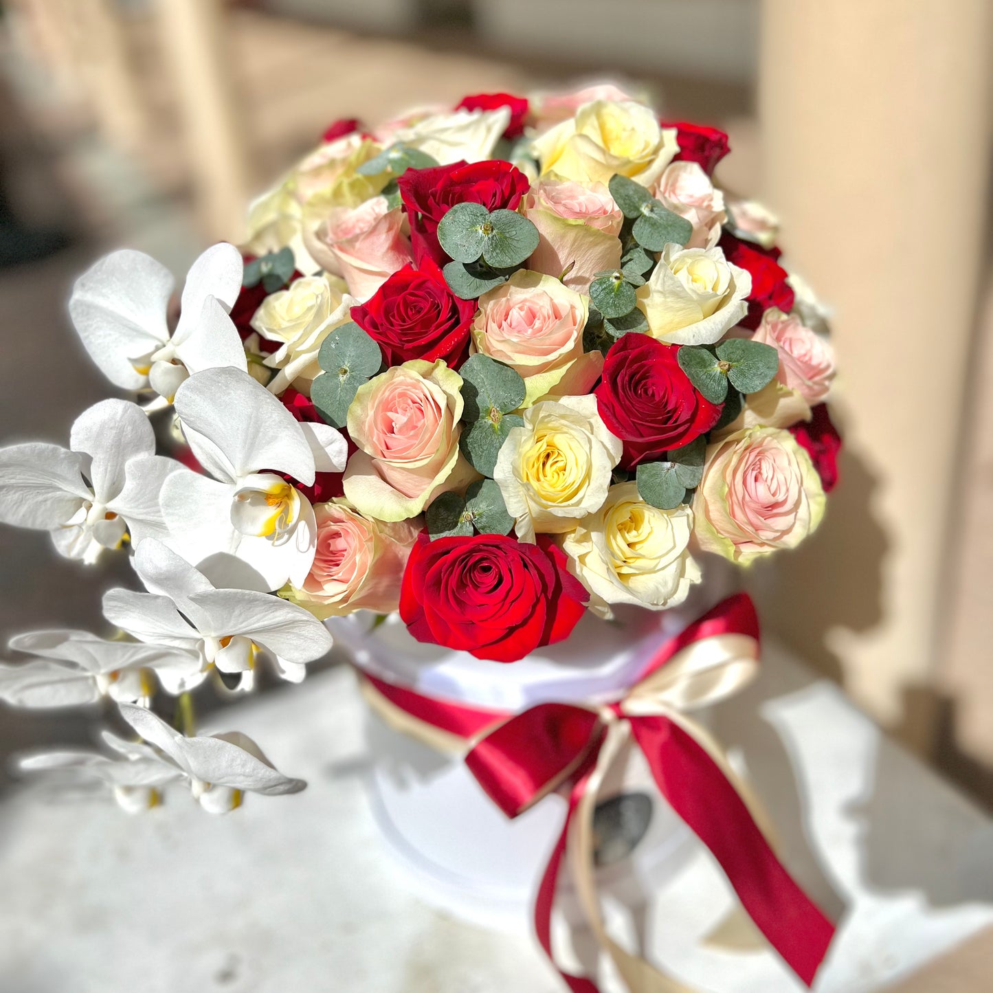 Potrait of red yellow roses on bench with red and white ribbon