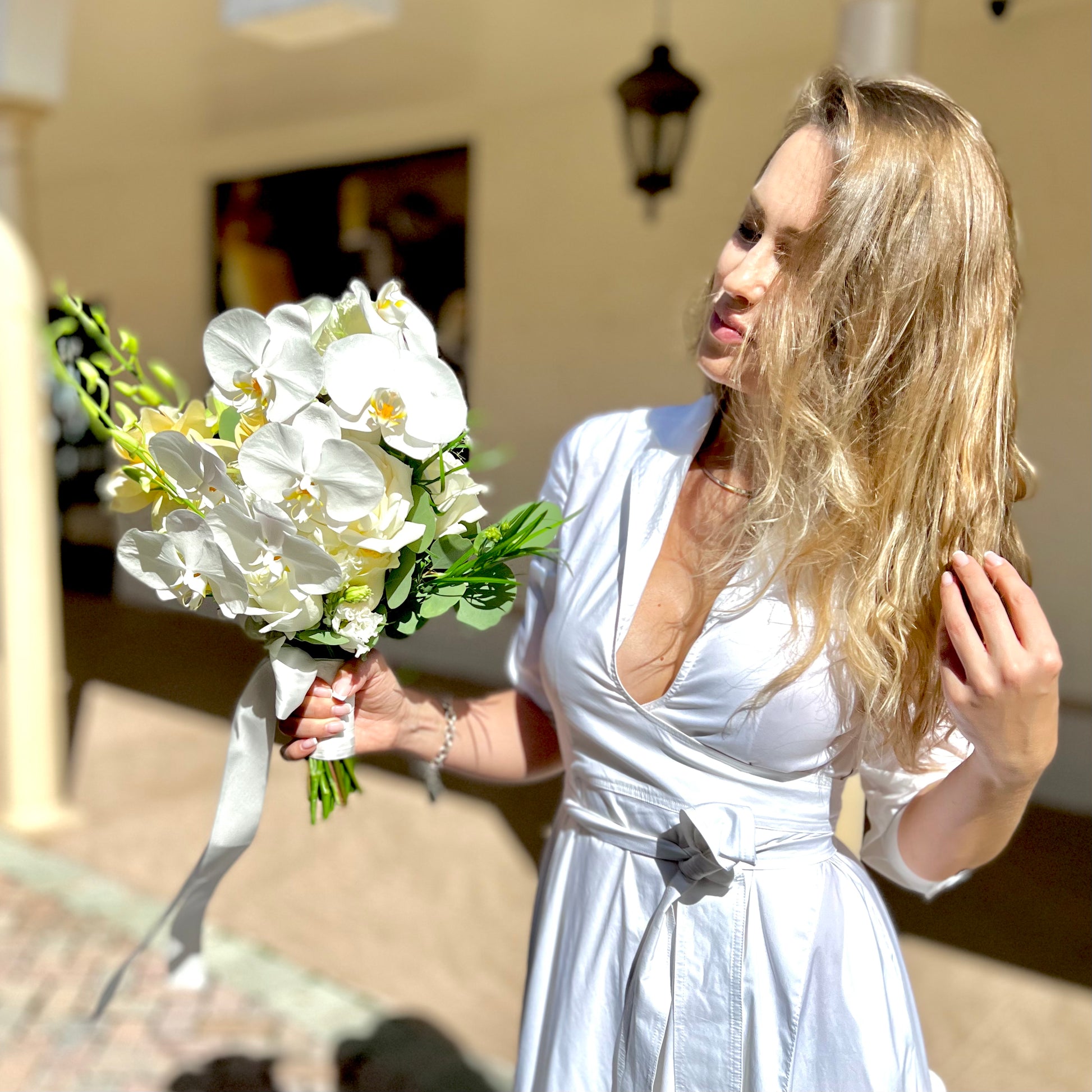 A woman with brown hair holding Bridal Bouquet with Orchids